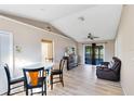 Open concept living area featuring wood-look tile flooring, vaulted ceilings, and sliding glass doors to the patio at 907 Robinson Ave, St Cloud, FL 34769