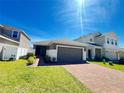 Beautiful single Gathering home with a well-maintained lawn, brick paver driveway and attached two car garage at 939 Anna Pl, Davenport, FL 33837