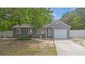 Lovely gray home featuring a single-car garage, and mature landscaping at 9513 Bahia Rd, Ocala, FL 34472
