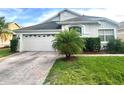 Charming single-story home featuring a two-car garage, lush lawn, and well-manicured landscaping at 14313 Dulcimer Ct, Orlando, FL 32837