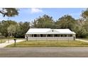 Charming single-story home with a metal roof, a long front porch, and a well-maintained lawn at 616 Se 31St Ter, Ocala, FL 34471