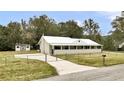 Charming single-story home with a metal roof, fenced yard, a shed, and a long driveway at 616 Se 31St Ter, Ocala, FL 34471