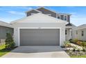 Exterior of home featuring a two-car garage, landscaping and neutral color scheme at 6393 Clover St, Lake Hamilton, FL 33851