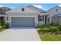 Single-Gathering home with a gray garage door, light stone details, and well-maintained landscaping at 6397 Clover St, Lake Hamilton, FL 33851