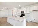 Modern kitchen features white cabinetry, stainless steel appliances, and a spacious center island at 6397 Clover St, Lake Hamilton, FL 33851