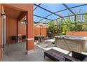 Relaxing screened-in patio features a hot tub, ample seating, and a tranquil view at 2618 Roadster Ln, Kissimmee, FL 34746
