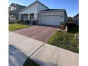 Charming single-Gathering home featuring a brick driveway, covered porch, and lush landscaping at 9083 Coral Cape St, Kissimmee, FL 34747
