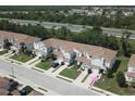 Aerial view of townhomes with manicured lawns, mature trees, and convenient access to the nearby highway at 2575 Aventurine St, Kissimmee, FL 34744