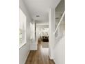 Bright hallway with hardwood floors, white walls, and staircase leading to the upper level at 3341 Rodrick Cir, Orlando, FL 32824