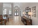Inviting entryway with tile flooring, decorative console table and frosted glass double doors at 3852 Brantley Place Cir, Apopka, FL 32703