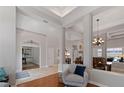 Open-concept living area with hardwood flooring, statement chandelier, and elegant columns at 3852 Brantley Place Cir, Apopka, FL 32703