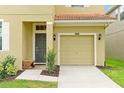 Close up view of a single-car garage and covered front door with bench at 8904 Candy Palm Rd, Kissimmee, FL 34747