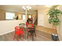 Cozy dining area with a glass-top table, colorful chairs, and a staircase leading to the second floor at 1039 Tourmaline Dr, Kissimmee, FL 34746