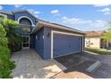 Close up of the attached two-car garage with tiled front patio and well-kept lawn at 1067 Ronlin St, Haines City, FL 33844