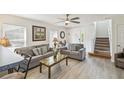 Inviting living room with plush sofas, a ceiling fan, and a staircase leading to the upper level at 1119 Mariner Cay Dr, Haines City, FL 33844
