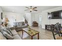 Bright living room featuring a comfortable couch, ceiling fan, wood-look floors, and a television at 1119 Mariner Cay Dr, Haines City, FL 33844