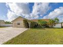 Charming single-story home with lush landscaping, arched entryway, and a brick driveway at 11242 Stone Gate Ct, Orlando, FL 32837