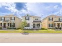 Inviting two-story house with a quaint front porch, enhanced by lush landscaping and a vibrant green lawn at 11456 Rhyme Ave, Orlando, FL 32832