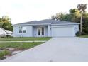 Charming single-story home with light blue exterior, white trim, and a well-manicured lawn at 1400 Fair Oaks Ave, Kissimmee, FL 34744
