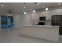 Open-concept kitchen featuring a spacious island, modern appliances, sleek white cabinetry and an adjacent dining area at 1400 Fair Oaks Ave, Kissimmee, FL 34744