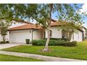 Attractive one-story home with a red tile roof, manicured lawn, and two-car garage at 16621 Caribbean Breeze Way, Clermont, FL 34714