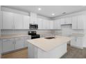 Modern kitchen featuring white cabinetry, stainless steel appliances, quartz countertops and a large center island at 1747 Carnelian St, Deland, FL 32720