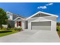 Charming single-Gathering home featuring a well-manicured lawn, gray exterior paint, and an attached two-car garage at 1749 Carnelian St, Deland, FL 32720