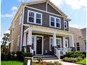 Attractive two-story home displaying a cozy front porch with columns and meticulously maintained landscaping at 2057 Celebration Blvd, Celebration, FL 34747