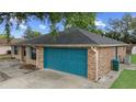 Back exterior of the house featuring an attached blue garage and a well-maintained backyard at 2081 N Normandy Blvd, Deltona, FL 32725