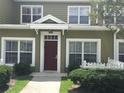 Inviting townhouse exterior with a maroon front door and well-manicured bushes at 2610 Lodi Cir # 104, Kissimmee, FL 34746