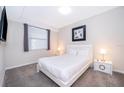 A cozy bedroom features a queen bed with fresh linens, bedside tables and a window with blinds at 3120 Paradox Cir # 302, Kissimmee, FL 34746