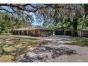 Spacious home featuring a detached garage, long driveway, and lush landscaping, offering ample parking and curb appeal at 6340 Nelms E Rd, Lakeland, FL 33811