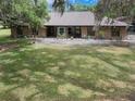 Charming single-story brick home with a well-manicured lawn and mature trees draped with Spanish moss at 6340 Nelms E Rd, Lakeland, FL 33811