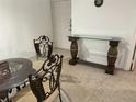 Dining area showcasing a glass table with ornate chairs and a matching console table at 8907 Legacy Ct # 14 205, Kissimmee, FL 34747