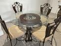 A dining area with an elegant glass-topped table and ornate metal chairs at 8907 Legacy Ct # 14 205, Kissimmee, FL 34747