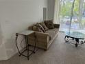 A cozy living room with a comfortable couch, stylish side table, and glass coffee table at 8907 Legacy Ct # 14 205, Kissimmee, FL 34747