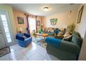 Comfortable living room featuring tile flooring, a large window, and a cozy seating arrangement at 905 Gloucester Ct, Kissimmee, FL 34758
