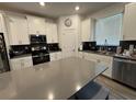 Modern kitchen featuring white cabinets, stainless steel appliances, and a large center island at 11312 Listening Dr, Orlando, FL 32832
