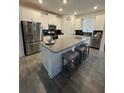 Well-lit kitchen with white cabinetry, a center island with seating, and stainless steel appliances at 11312 Listening Dr, Orlando, FL 32832