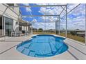 Inviting private screened pool with an outdoor dining set, perfect for relaxation and entertaining at 107 Troon Cir, Davenport, FL 33897