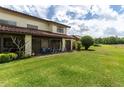 Exterior image featuring a spacious backyard with lush green grass and a comfortable patio seating area at 117 Coventry Ln, Haines City, FL 33844