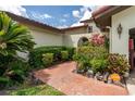 Charming home entrance with lush plants, and a stone walkway leading to an inviting gated entry at 117 Coventry Ln, Haines City, FL 33844