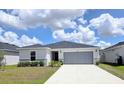 Well-maintained home features a two-car garage and manicured lawn at 1241 Denali Dr, Winter Haven, FL 33881