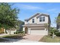Two-story home with a brick driveway, a two-car garage, and well-maintained landscaping in a sunny setting at 1338 Riley Cir, Deland, FL 32724