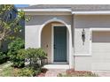 Inviting front entrance featuring an arched doorway, a teal-colored door, and manicured landscaping at 1338 Riley Cir, Deland, FL 32724