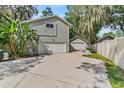 Home featuring a detached garage, mature landscaping, and an inviting driveway at 13959 Marine Dr, Orlando, FL 32832