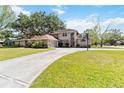 Two-story home with a long driveway, a basketball hoop, and well-maintained front lawn at 1730 King Henry Dr, Kissimmee, FL 34744