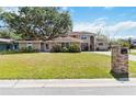Charming two-story home with manicured lawn, lush landscaping, and brick mailbox on a sunny day at 1730 King Henry Dr, Kissimmee, FL 34744
