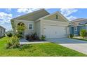 Well-maintained one-story house featuring an attached two-car garage, green lawn, and tidy landscaping at 1774 Walnut Creek Dr, Kissimmee, FL 34744