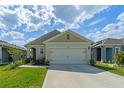 Charming single-story home featuring a well-kept lawn, an attached two-car garage and neutral-toned exterior at 1774 Walnut Creek Dr, Kissimmee, FL 34744